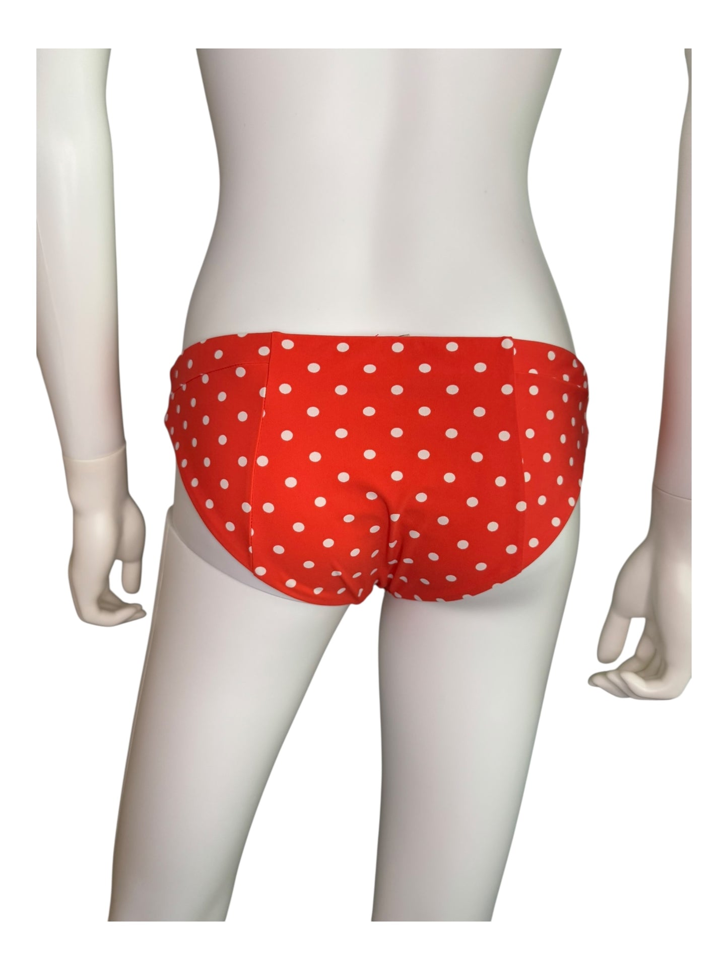 Red polka dot bikini bottom on a mannequin against a white background