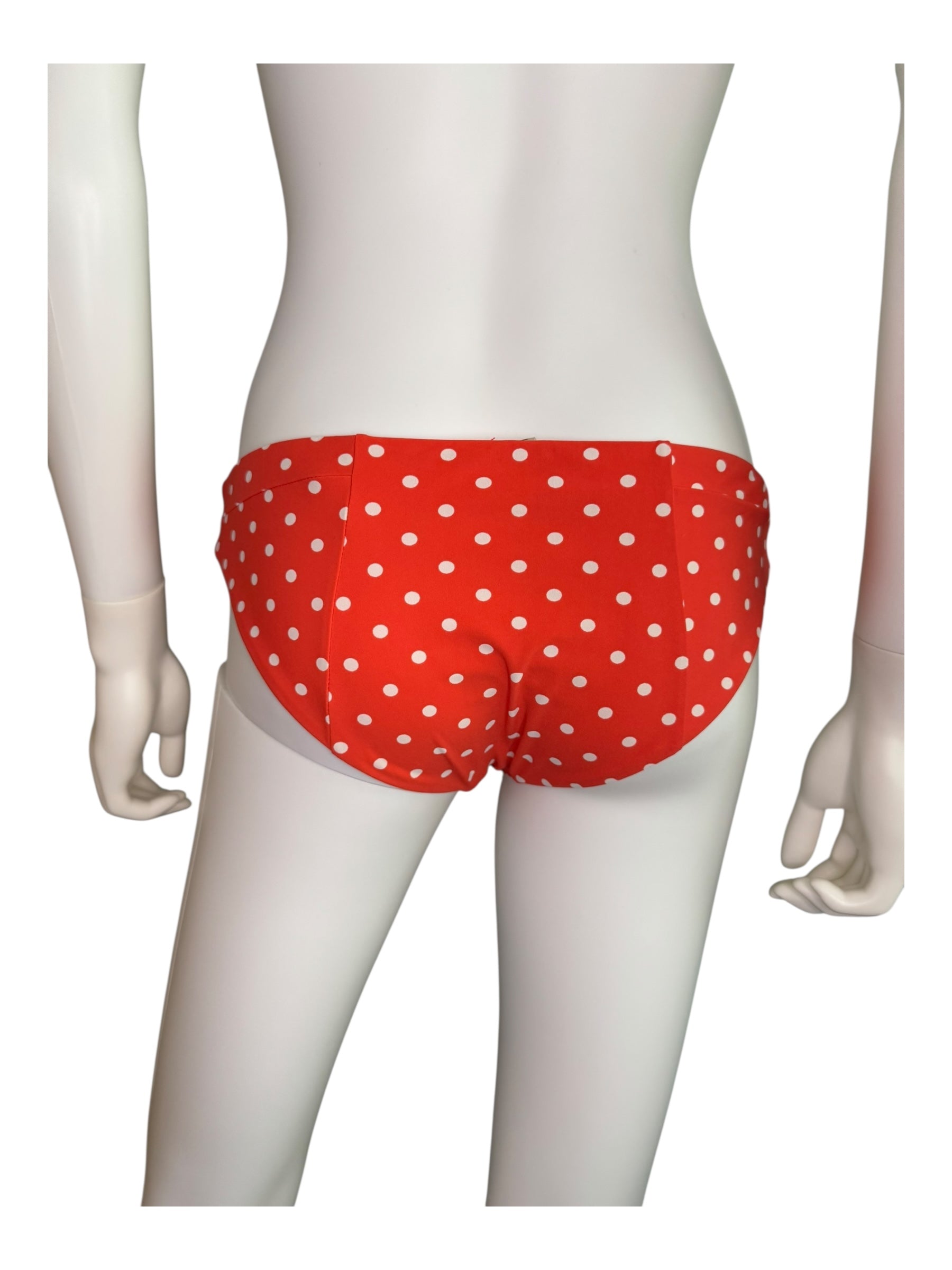 Red polka dot bikini bottom on a mannequin against a white background