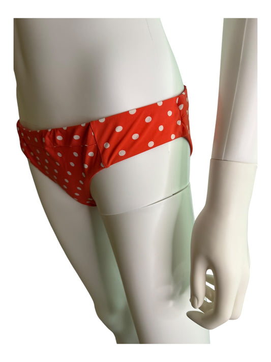 Red polka dot bikini bottom on a mannequin against a white background